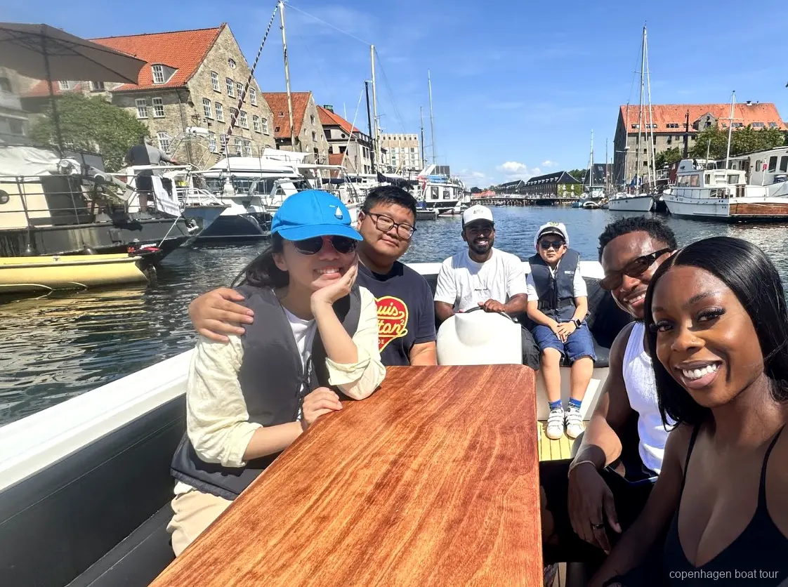 Visiteur tenant la barre sous supervision du guide sur le tour en bateau de luxe à Copenhague