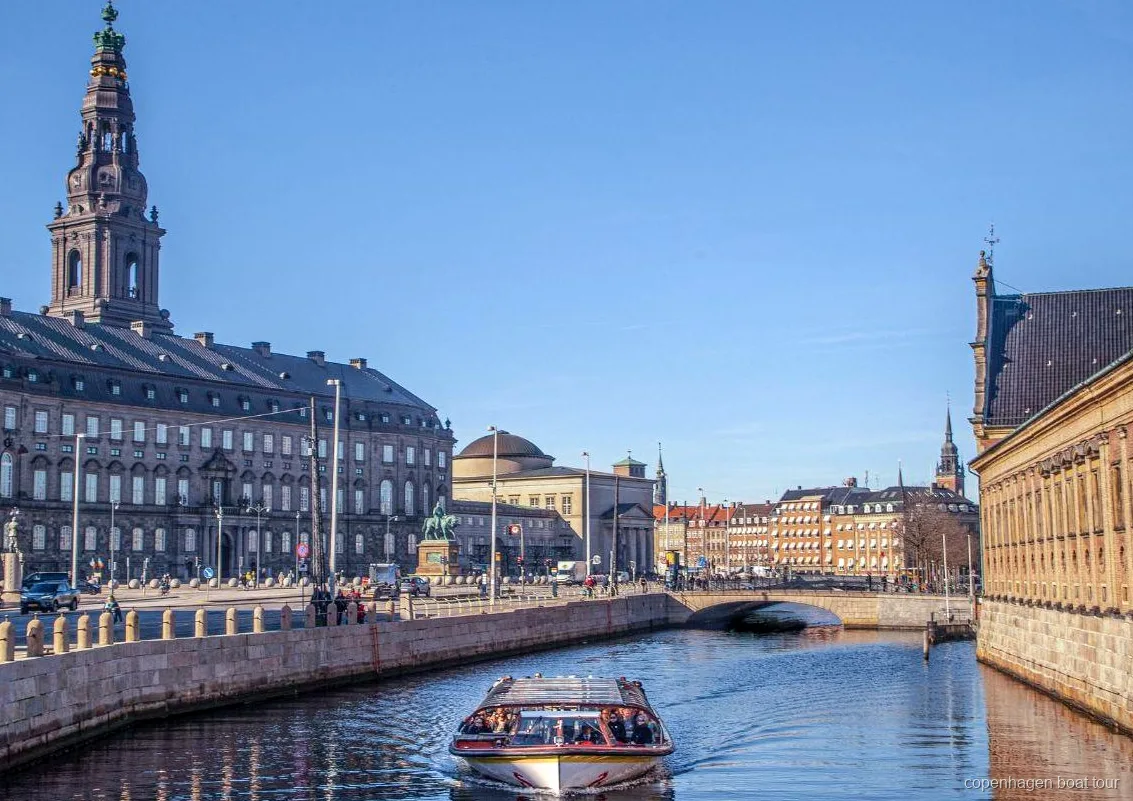 Copenhagen canal cruise boat with drinks served onboard passing the harbor