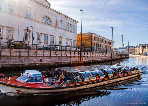 Bateau de la croisière sur les canaux de Copenhague passant devant des bâtiments historiques près de Ved Stranden