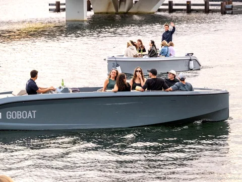 Elektrische boot op de elektrische boottocht Kopenhagen vaart langs gebouwen aan de haven