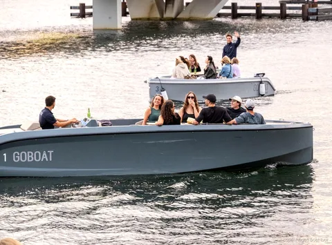 Elektroboot der Kopenhagen Elektrischen Kanaltour fährt an Hafenfrontgebäuden vorbei