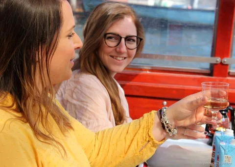 Kapalı bir Kopenhag kanal turu teknesinde içecek keyfi yapan grup