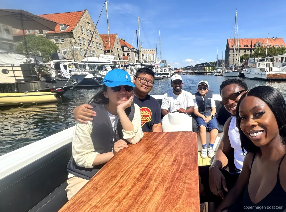 Visitante dirigiendo el barco bajo supervisión del guía en el paseo en barco de lujo de Copenhague